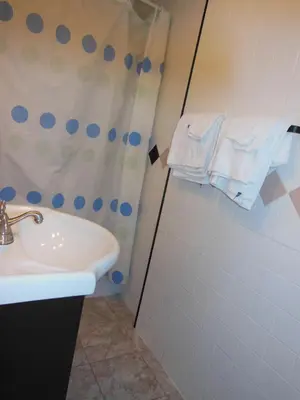 a bathroom with a shower curtain and a sink at Motel Pierre in Montréal