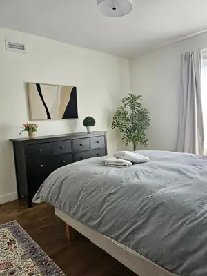 a bedroom with a bed with a dresser and a mirror at Le Mont-Royal Sky by HomeInMontreal in Montréal