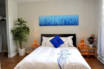 a bedroom with a large white bed with blue pillows at Le Mont-Royal Sky by HomeInMontreal in Montréal