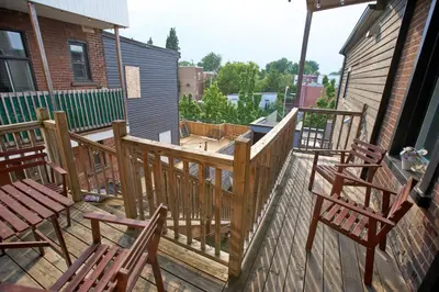 a balcony with two chairs and a wooden deck at Le Mont-Royal Sky by HomeInMontreal in Montréal