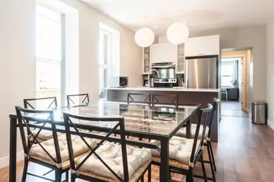 a dining room with a glass table and chairs at Le Mont-Royal Sky by HomeInMontreal in Montréal