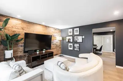 a living room with white furniture and a flat screen tv at Appart M1 avec bain tourbillon citq 309409 in Mascouche