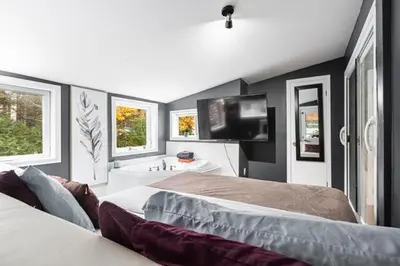 a bedroom with two beds and a flat screen tv at Appart M1 avec bain tourbillon citq 309409 in Mascouche