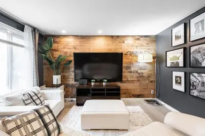a living room with a couch and a flat screen tv at Appart M1 avec bain tourbillon citq 309409 in Mascouche