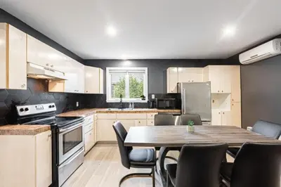 a kitchen with a table and chairs in it at Appart M1 avec bain tourbillon citq 309409 in Mascouche