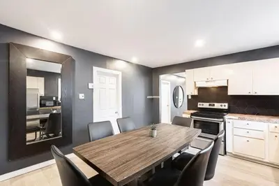 a dining room with a table and chairs and a kitchen at Appart M1 avec bain tourbillon citq 309409 in Mascouche