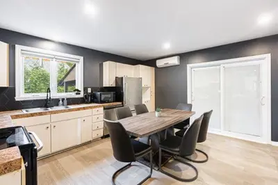 a kitchen with a table and chairs in a room at Appart M1 avec bain tourbillon citq 309409 in Mascouche