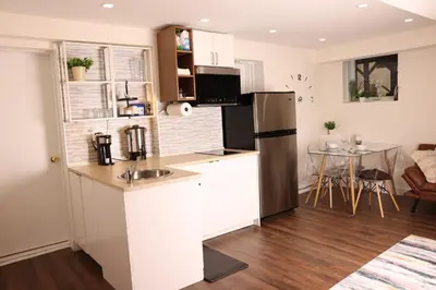 a kitchen with a stainless steel refrigerator and a table at bedford - Urban escape in Montréal