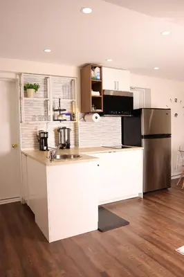 a kitchen with white cabinets and a stainless steel refrigerator at bedford - Urban escape in Montréal