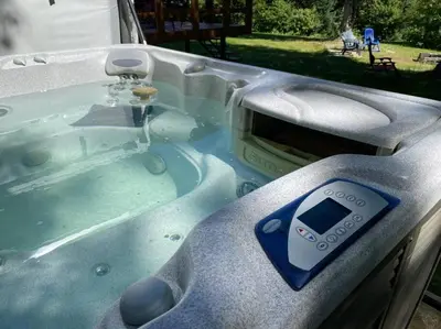 a hot tub with a remote control in it at LE JAZZ- Chalet rustique/chic avec SPA in Notre-Dame-Des-Bois