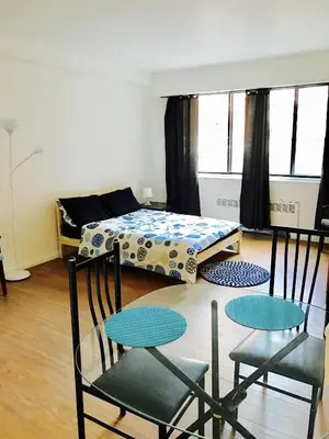 a room with two chairs and a table and a bed at Stylish Montreal Apartment: Comfortable Stay in the Golden Square Mile in Montréal