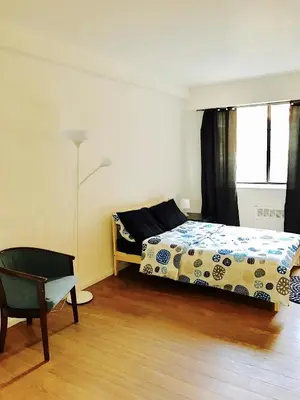 a bedroom with a bed and a chair and a window at Stylish Montreal Apartment: Comfortable Stay in the Golden Square Mile in Montréal