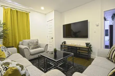 a living room with a couch and a tv at Downtown Prestige: Parking, King Bed, Sleeps 6 in Sherbrooke