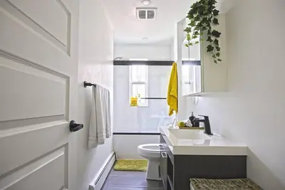 a white bathroom with a sink and a toilet at Downtown Prestige: Parking, King Bed, Sleeps 6 in Sherbrooke