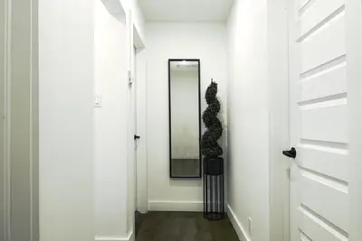 a hallway with a mirror and a plant on the wall at Downtown Prestige: Parking, King Bed, Sleeps 6 in Sherbrooke