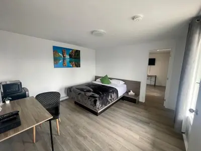 a bedroom with a bed and a desk and a table at Motel Saint Bruno in Saint-Bruno-de-Montarville