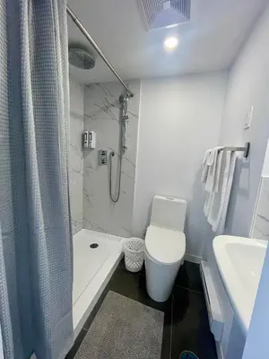 a bathroom with a toilet and a sink and a shower at Motel Saint Bruno in Saint-Bruno-de-Montarville
