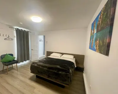 a bedroom with a bed and a chair in it at Motel Saint Bruno in Saint-Bruno-de-Montarville