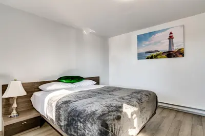 a white bedroom with a bed and a lighthouse at Motel Saint Bruno in Saint-Bruno-de-Montarville