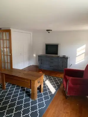 a living room with a couch and a table and a tv at Chalet de Mimi in Coaticook