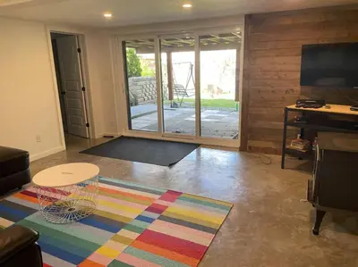 a living room with a table and a sliding glass door at Chalet de Mimi in Coaticook
