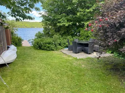a picnic table in the grass next to a lake at Chalet de Mimi in Coaticook