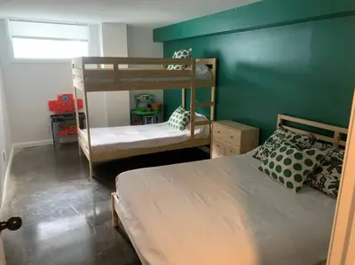 a bedroom with two bunk beds and a green wall at Chalet de Mimi in Coaticook