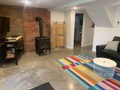 a living room with a couch and a wood stove at Chalet de Mimi in Coaticook