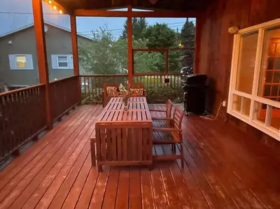 a deck with wooden tables and benches on a porch at Chalet de Mimi in Coaticook