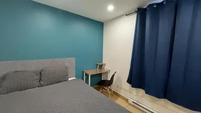 a bedroom with a bed and a blue wall at APD HOTEL in Montréal