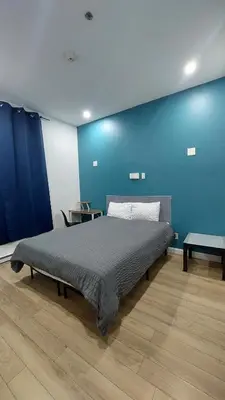 a bed in a room with a blue wall at APD HOTEL in Montréal