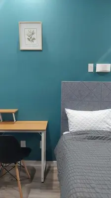 a bedroom with a desk and a bed with a blue wall at APD HOTEL in Montréal