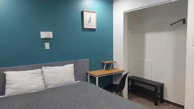 a bedroom with a blue wall and a bed and a desk at APD HOTEL in Montréal