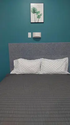 a bedroom with a bed with a blue wall at APD HOTEL in Montréal