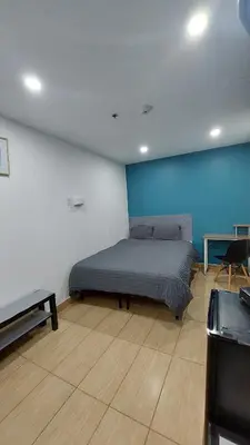 a bedroom with a bed and a blue wall at APD HOTEL in Montréal