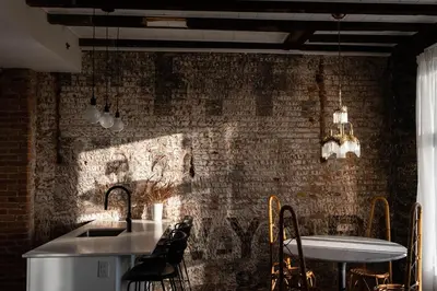 a kitchen with a brick wall and a sink at Maison Place Royale by Luxury In Transit in Montréal