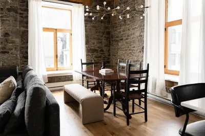 a dining room with a table and a couch at Maison Place Royale by Luxury In Transit in Montréal