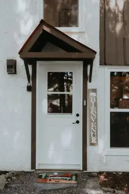 a white door with a brown roof on a building at Le Grizzli Orford in Orford