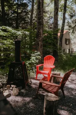 a red chair sitting next to a wood stove at Le Grizzli Orford in Orford