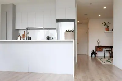 a kitchen and living room with white cabinets at Appartement de luxe avec piscine in Montréal