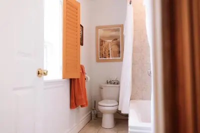 a bathroom with a toilet and a picture on the wall at Auberge Incroyable in Saint Adrien