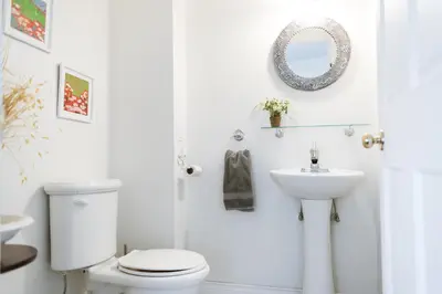 a white bathroom with a toilet and a sink at Auberge Incroyable in Saint Adrien