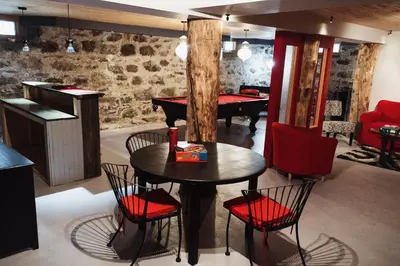 a room with a table and chairs and a pool table at Auberge Incroyable in Saint Adrien