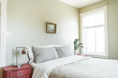 a bedroom with a bed with white sheets and a window at Auberge Incroyable in Saint Adrien