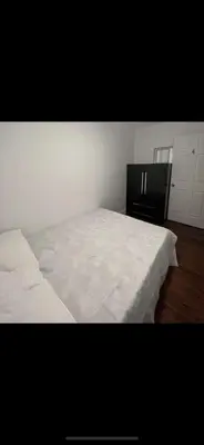 a bedroom with a white bed and a black cabinet at Self-service small breakfast private Room 1 in Montréal