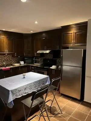a kitchen with a table and a refrigerator at Self-service small breakfast private Room 1 in Montréal