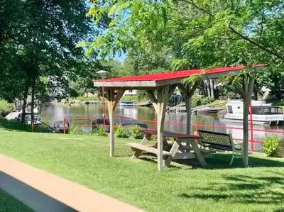 a picnic shelter with a bench next to a river at Loft in Louiseville