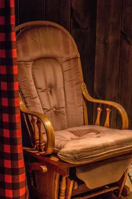 a wooden rocking chair sitting in a room at Mont Megantic - Chalet Le Madison in La Patrie