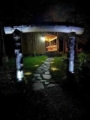 a pathway in a yard at night with lights at Mont Megantic - Chalet Le Madison in La Patrie
