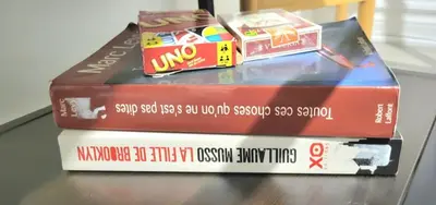 three books stacked on top of each other on a table at Cozy 1BR in Vieux-Longueuil +parking 14min Downtown in Longueuil